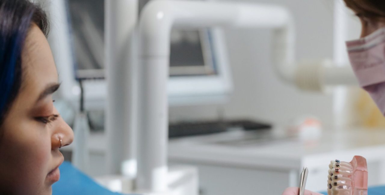 Dentist explaining a dental procedure with a teeth model